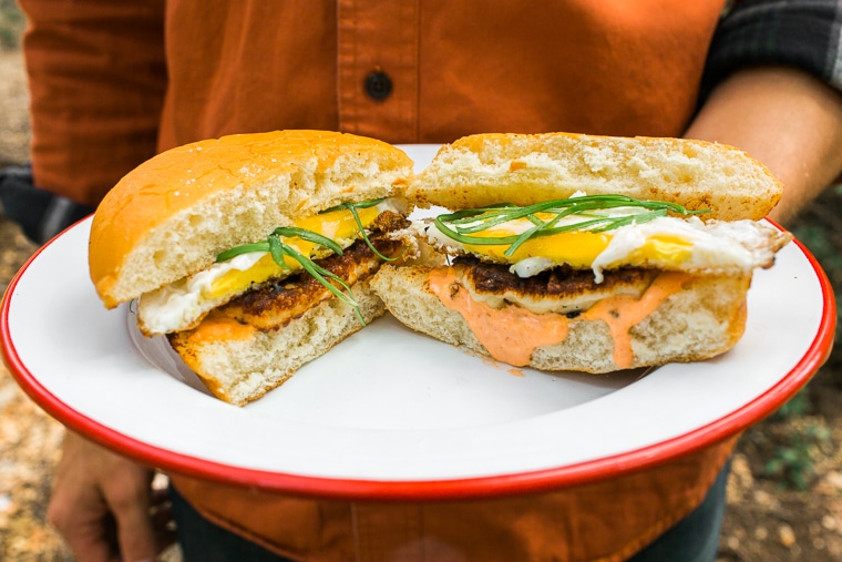 Michael holding a plate of breakfast sandwiches