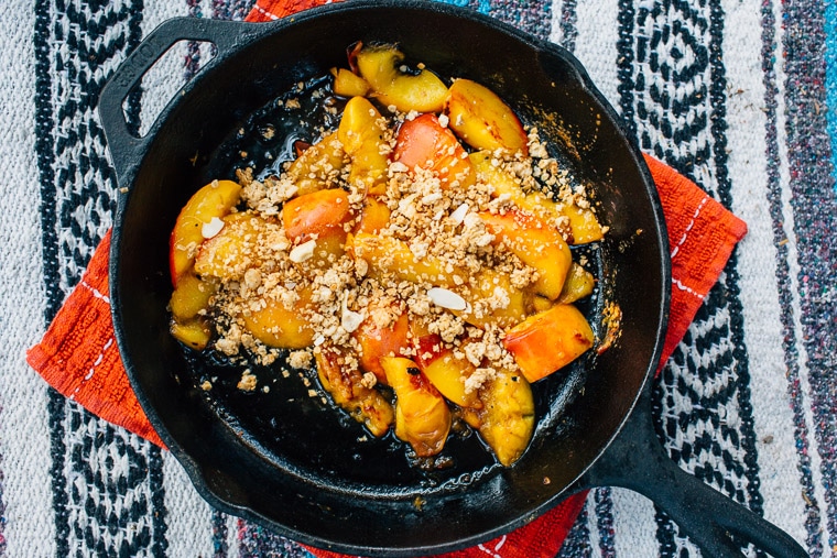 Peach crisp in a cast iron skillet on a table