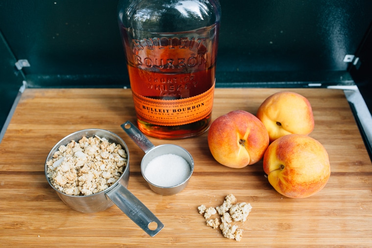 Ingredients for a peach crisp lined up on a cutting board