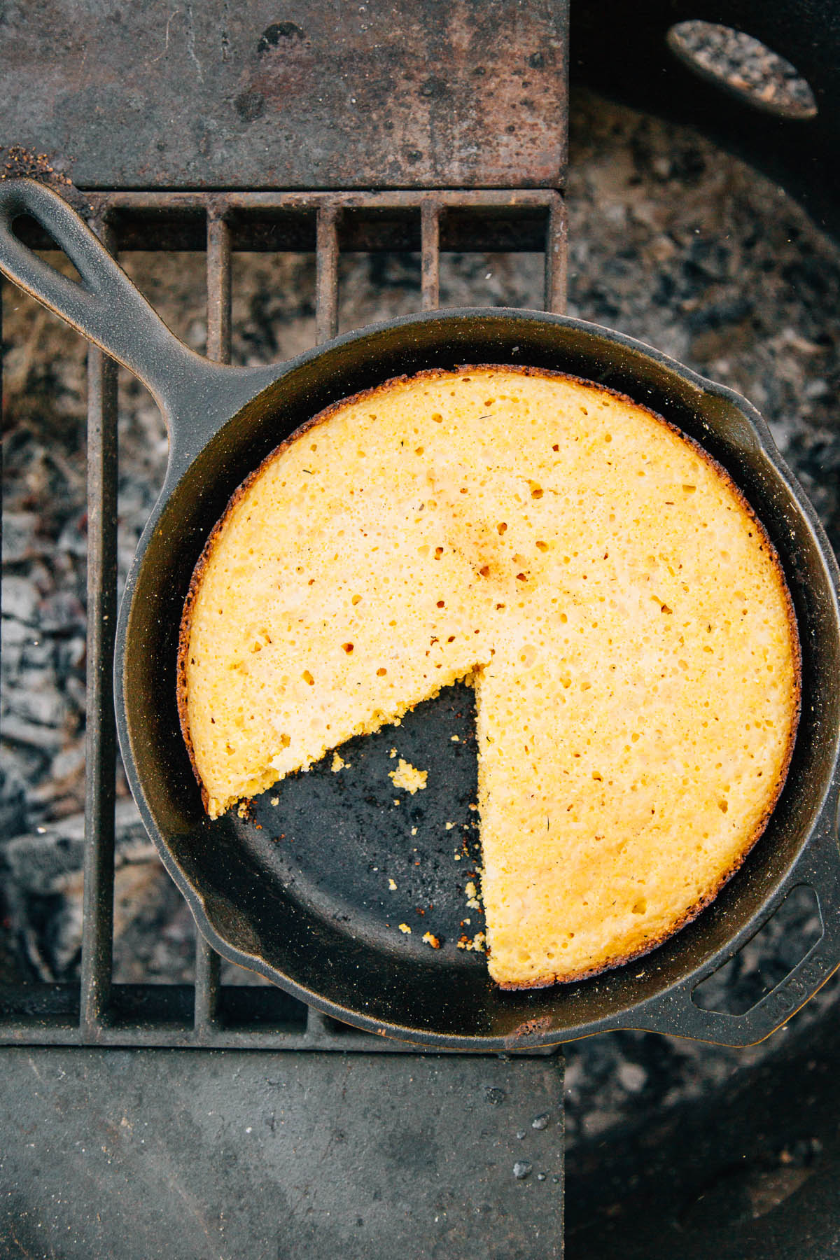 Cast iron skillet cornbread with a piece cut out