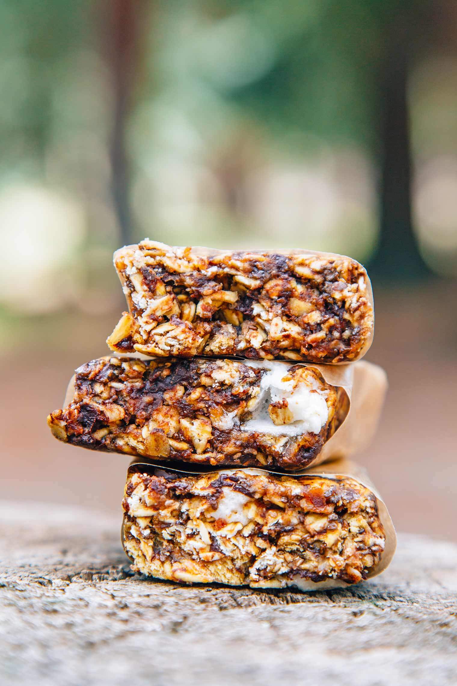 Three s'mores granola bars stacked on a log
