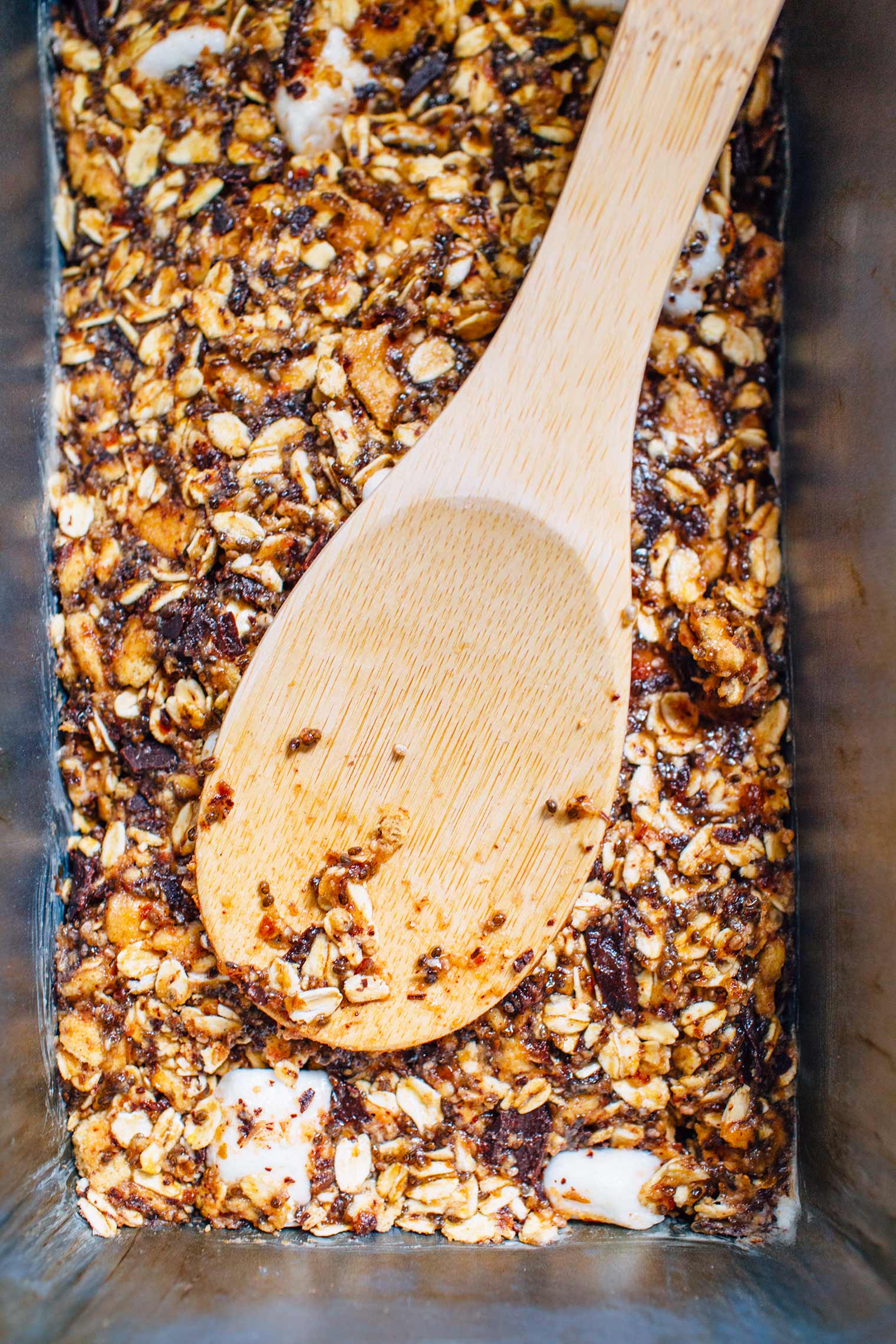 A spoon in a baking sheet of homemade granola bars