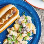 Potato salad and a hotdog on a blue camping plate