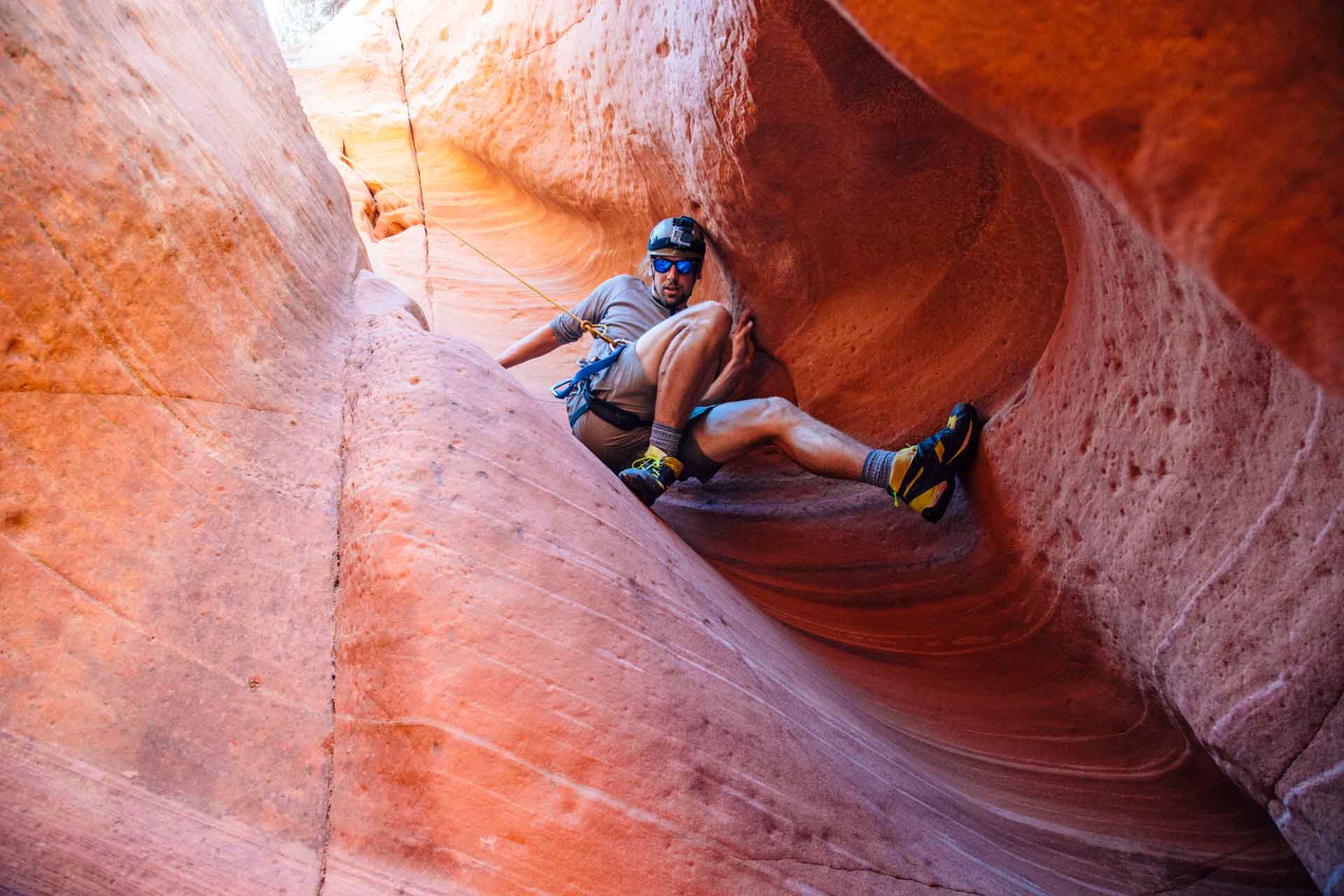 Michael down climbing into a slot canyon