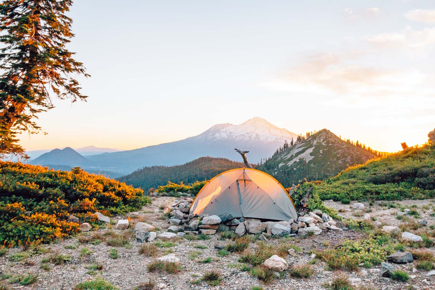 A backpacking tent set up with Mount Shasta in the distance