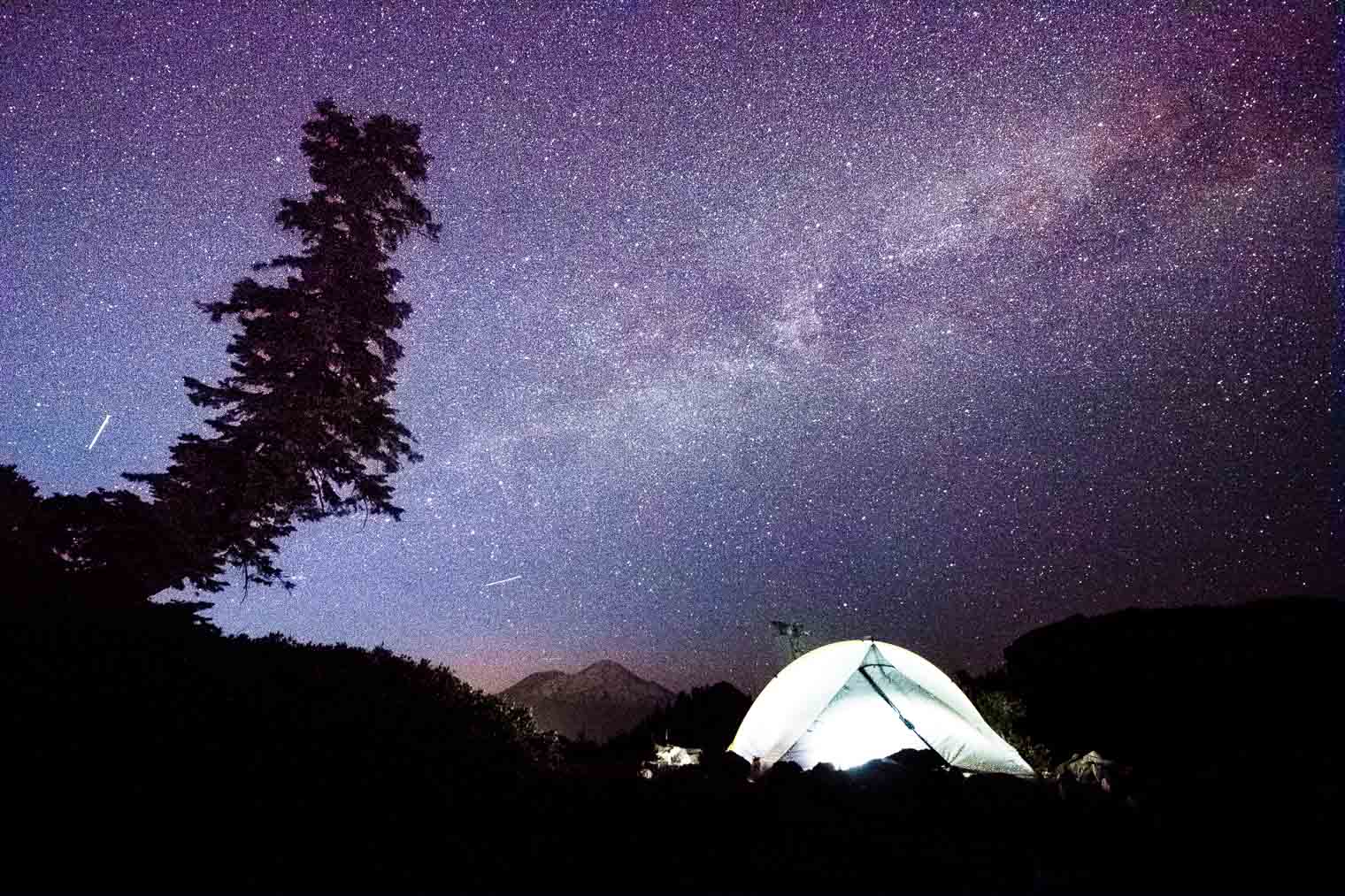 The silhouette of a tent Against a starry sky