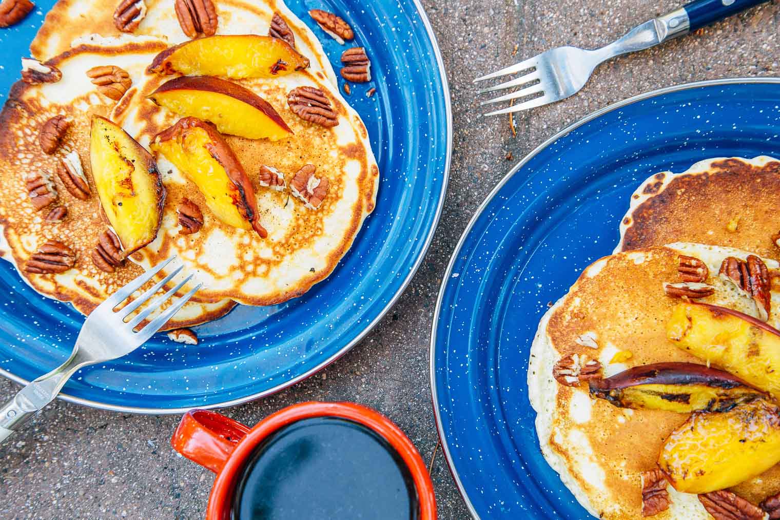 Two plates with peach pancakes stacked on them