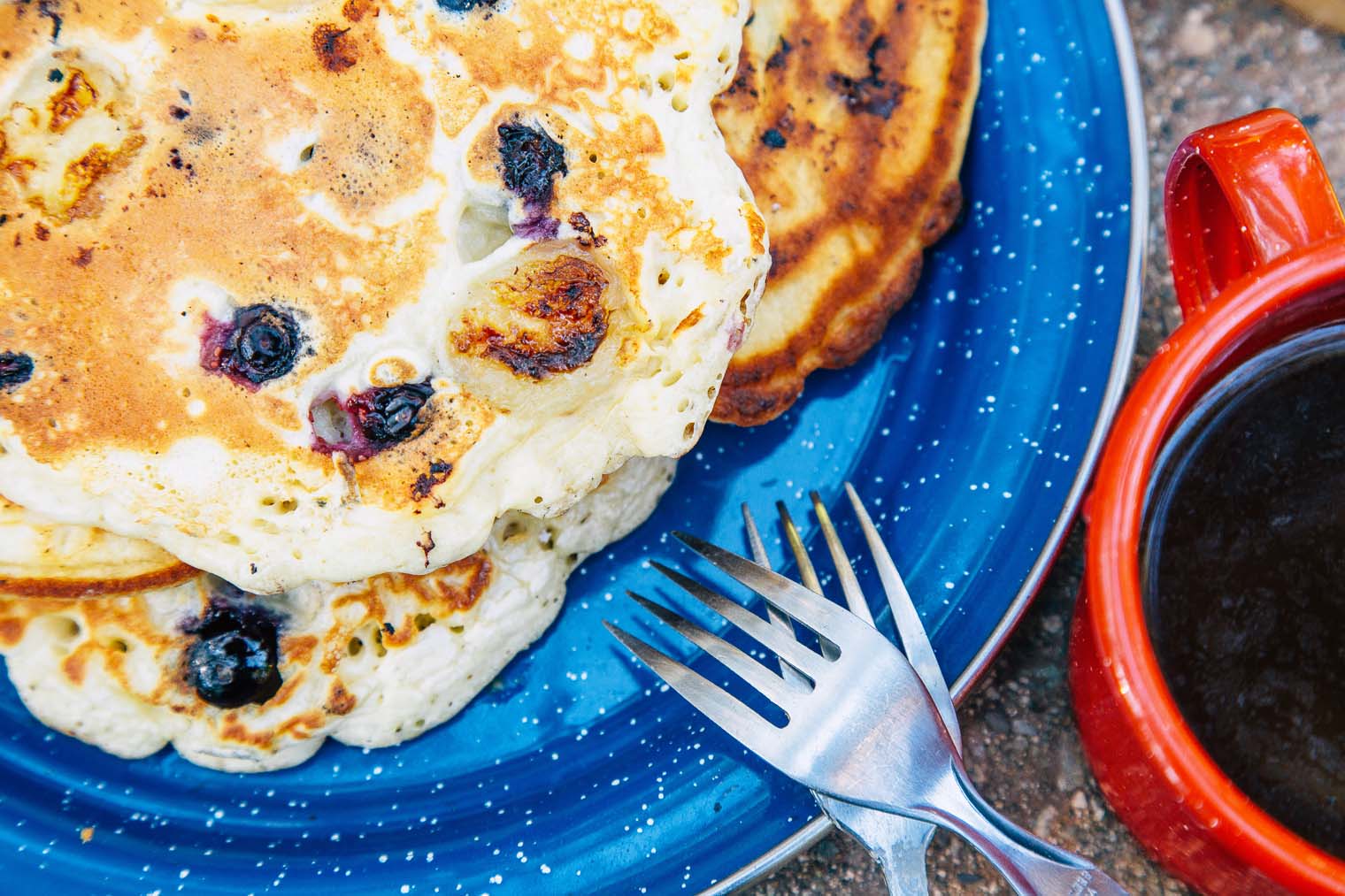 Blueberry pancakes on a blue camping plate