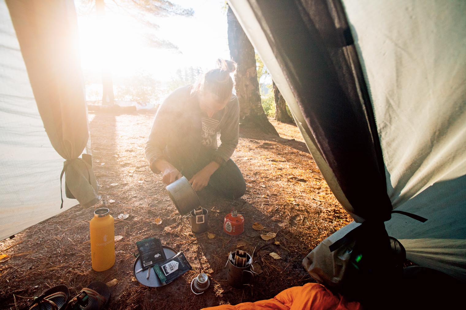 Michael making coffee in front of a backpacking tent