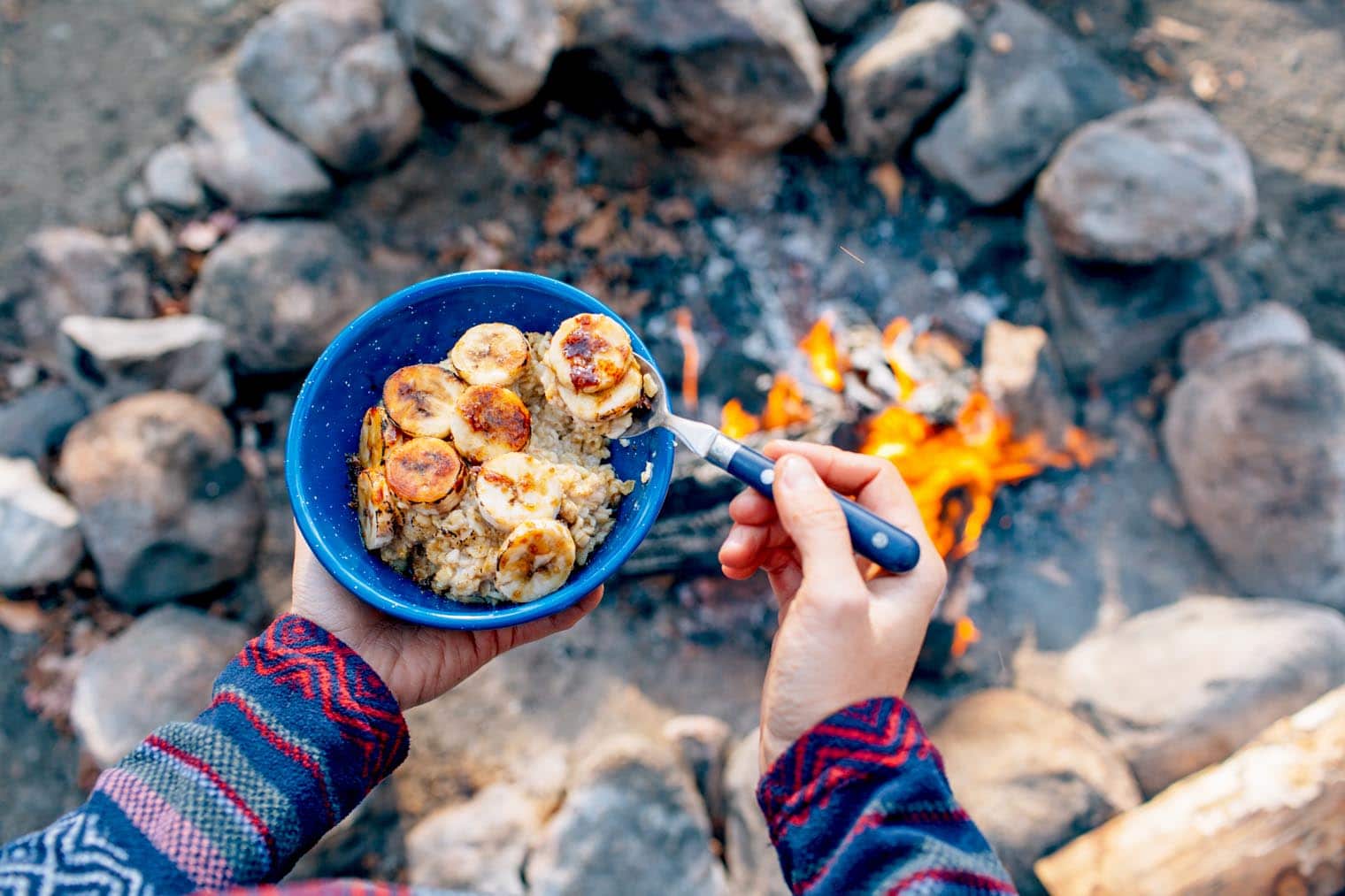 food on a camping trip Megan holding a bowl of oatmeal topped with bruleed bananas