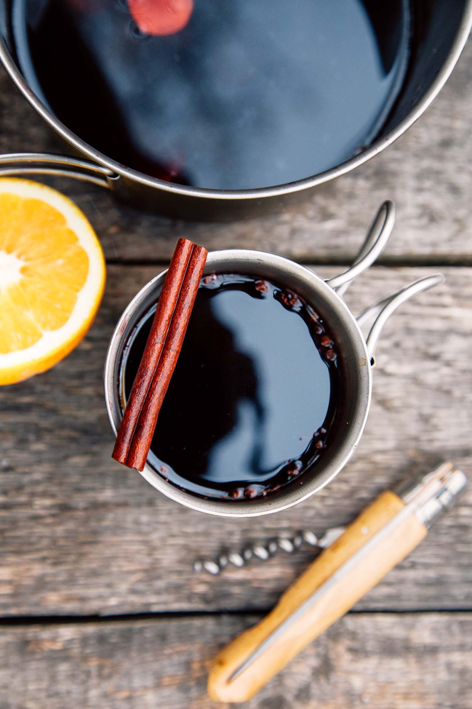 A mug and pot full of mulled wine on a camping table
