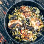 Chicken Marbella in a Dutch oven over a campfire