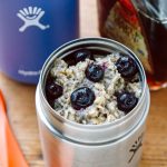 Oatmeal topped with blueberries inside a insulated food jar