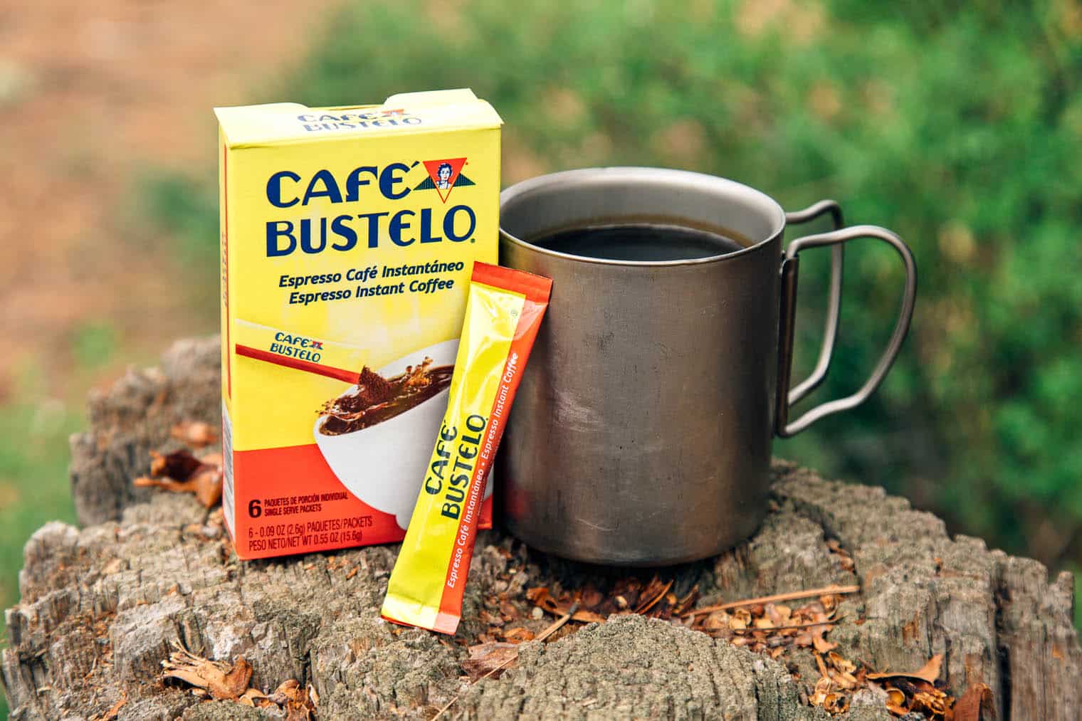 Cafe Bustelo instant coffee packaging next to a camp mug
