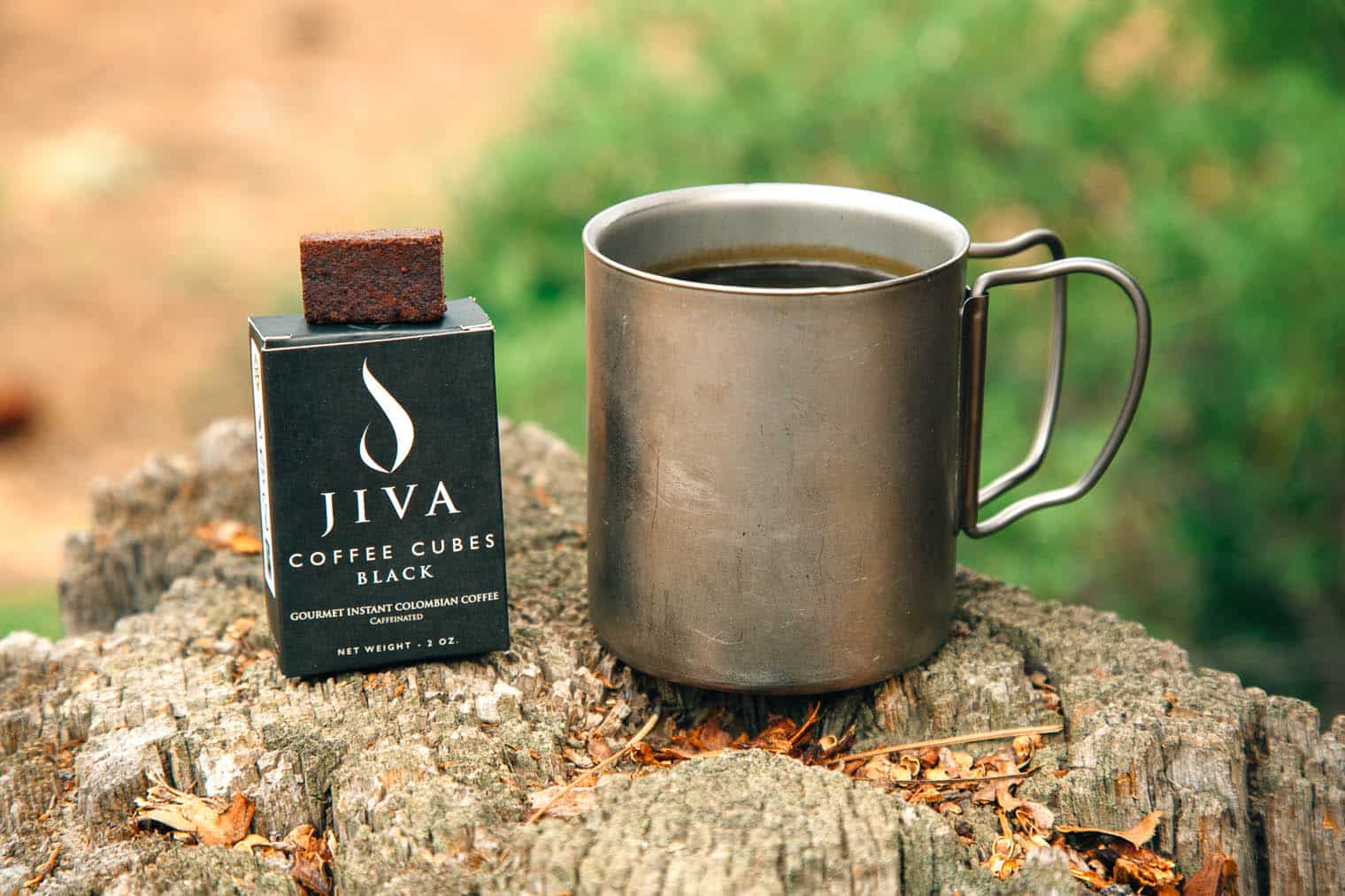 Jiva Cube instant coffee packaging next to a camp mug