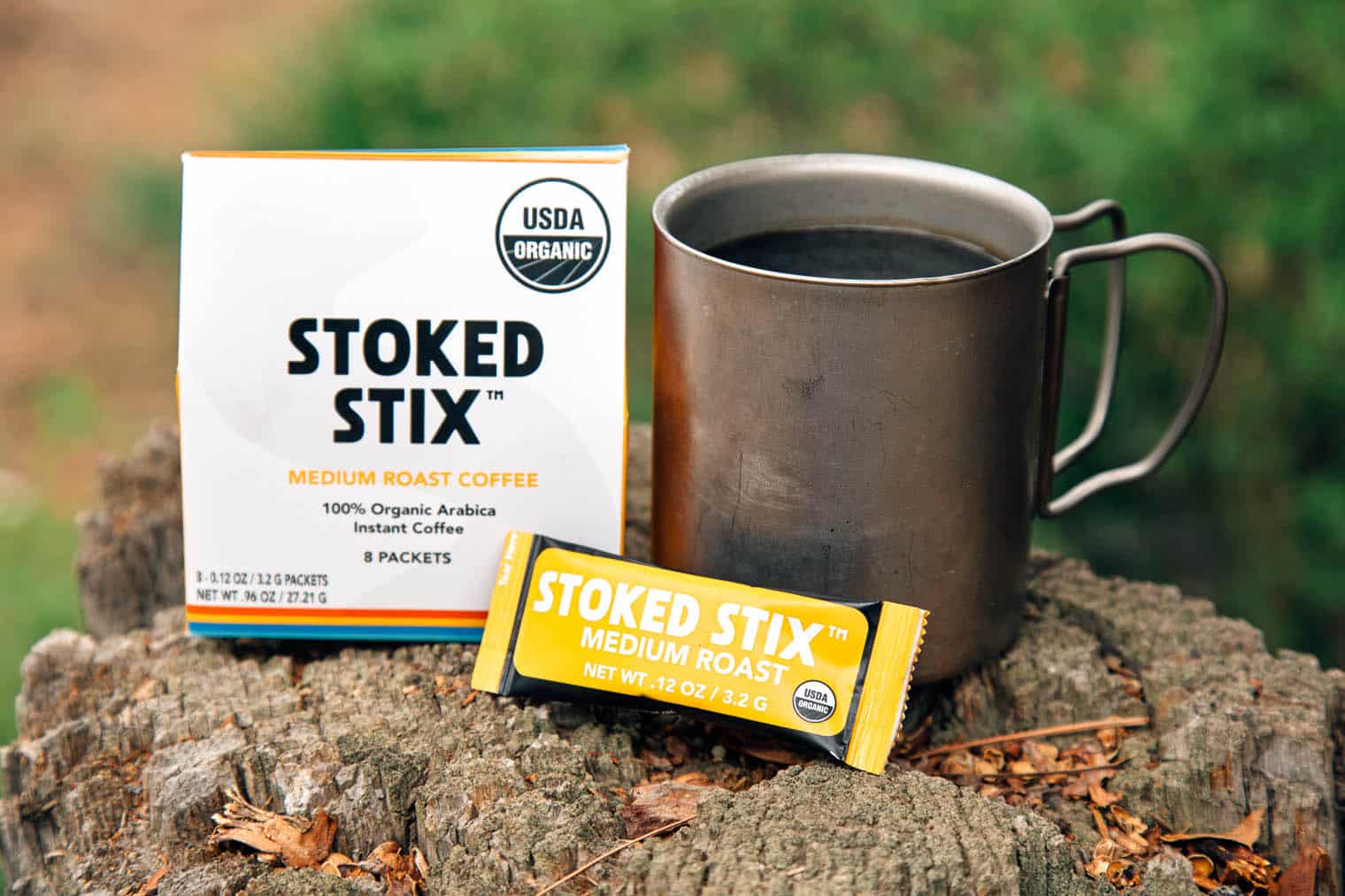 Stoked Stix  instant coffee packaging next to a camp mug