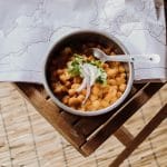 A bowl of chana masala on a table in a campervan