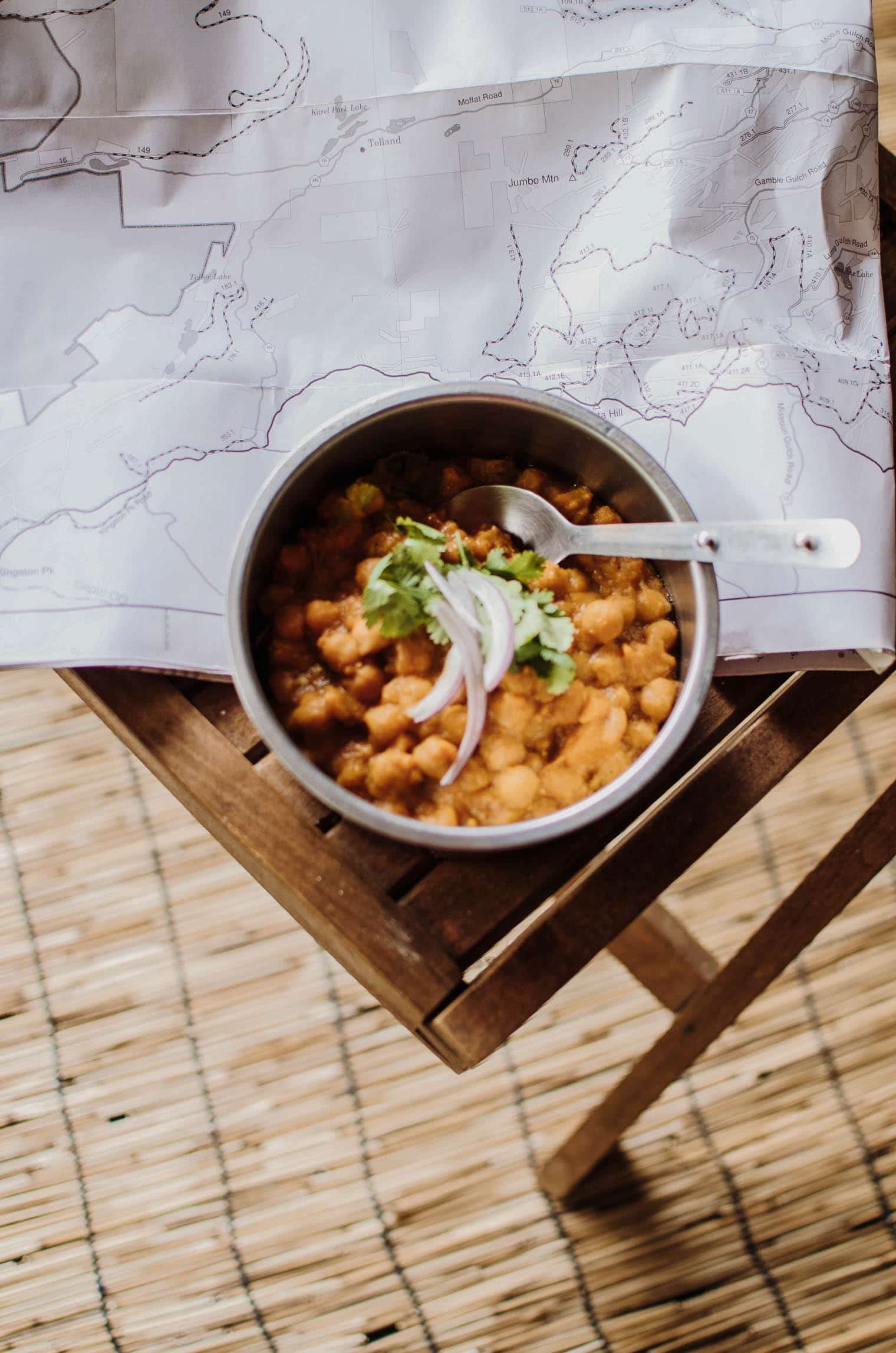 A bowl of chana masala on a table in a campervan