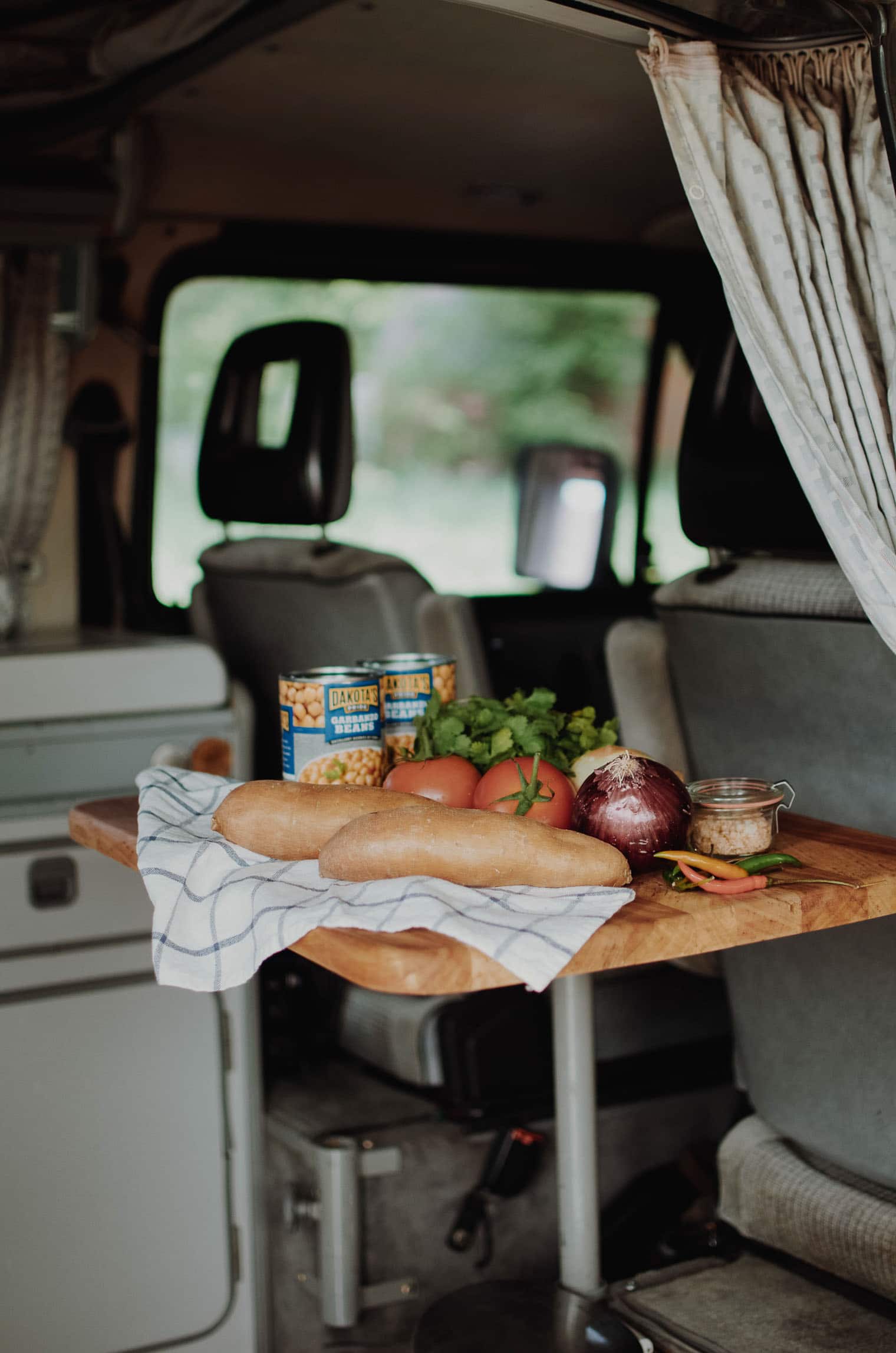 Ingredients for chana masala on a table in a campervan