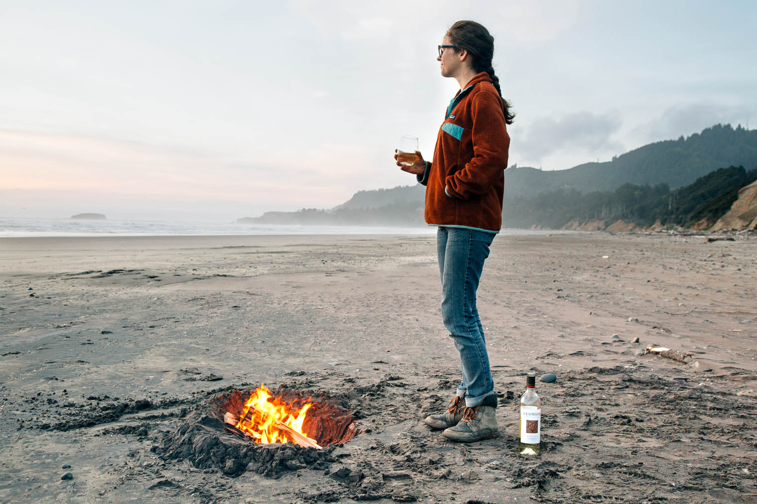 Megan standing in front of a bonfire on the beach along the Oregon Coast