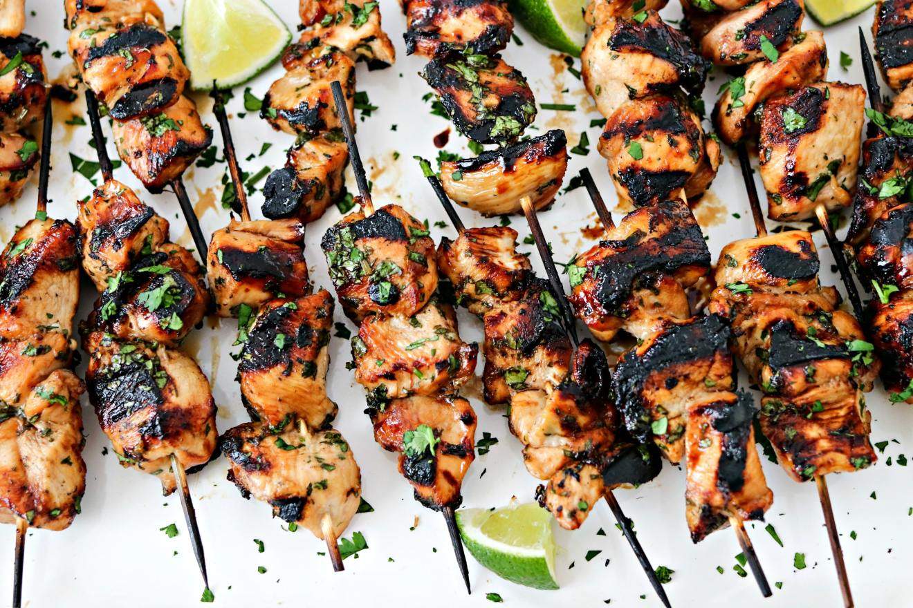 Grilled chicken skewers in a row