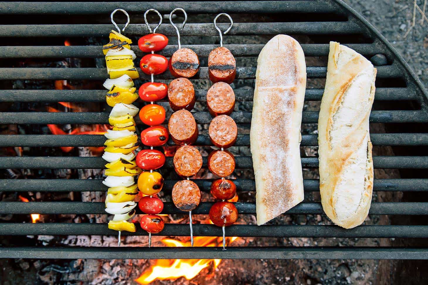 Grilling chorizo kebabs on the campfire