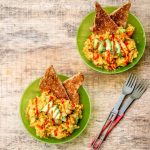 Chickpea breakfast scrambles in green bowls on a wooden surface