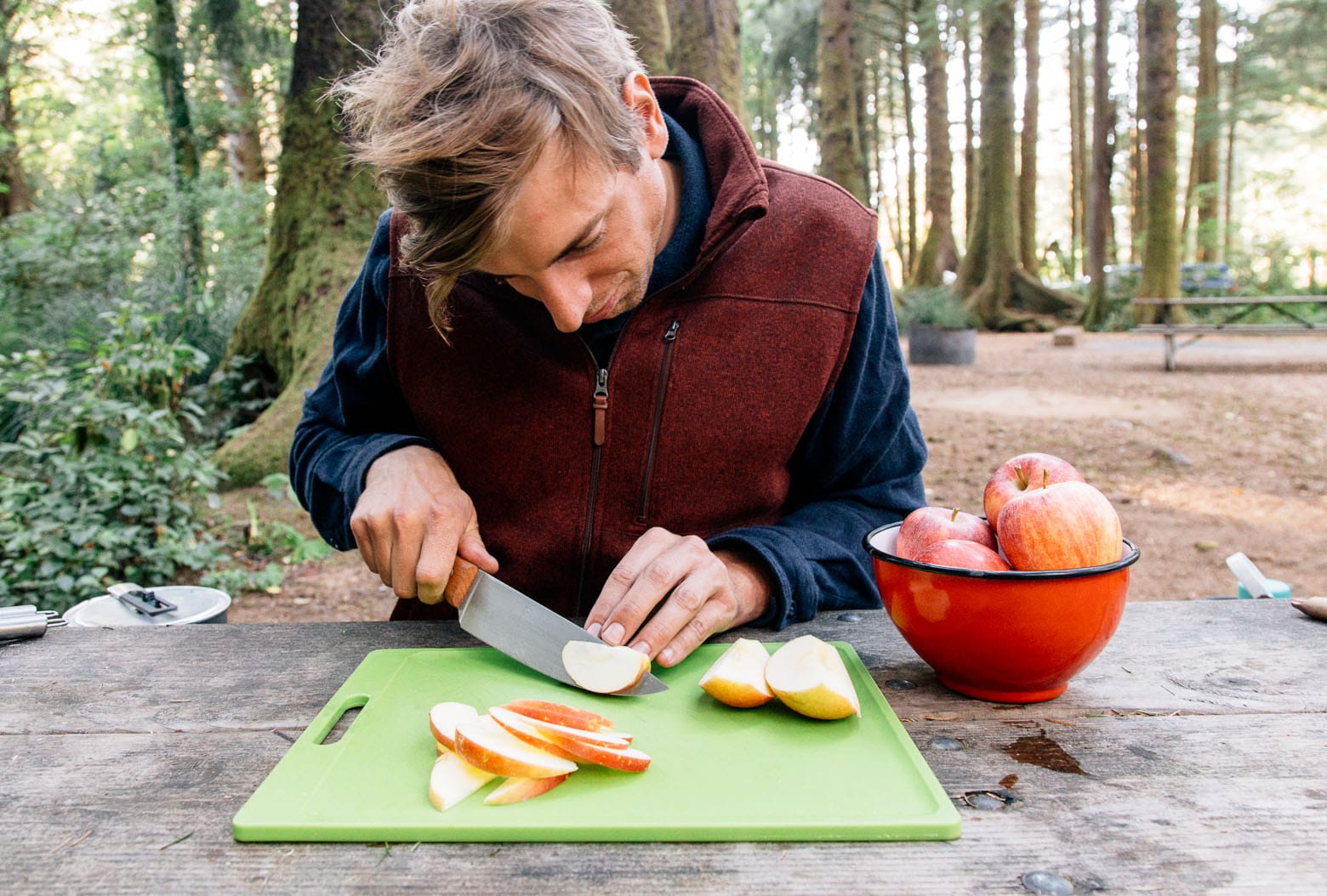 Michael slicing apples at a picnic tables