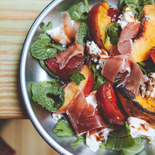 Caprese salad with grilled peaches on a plate