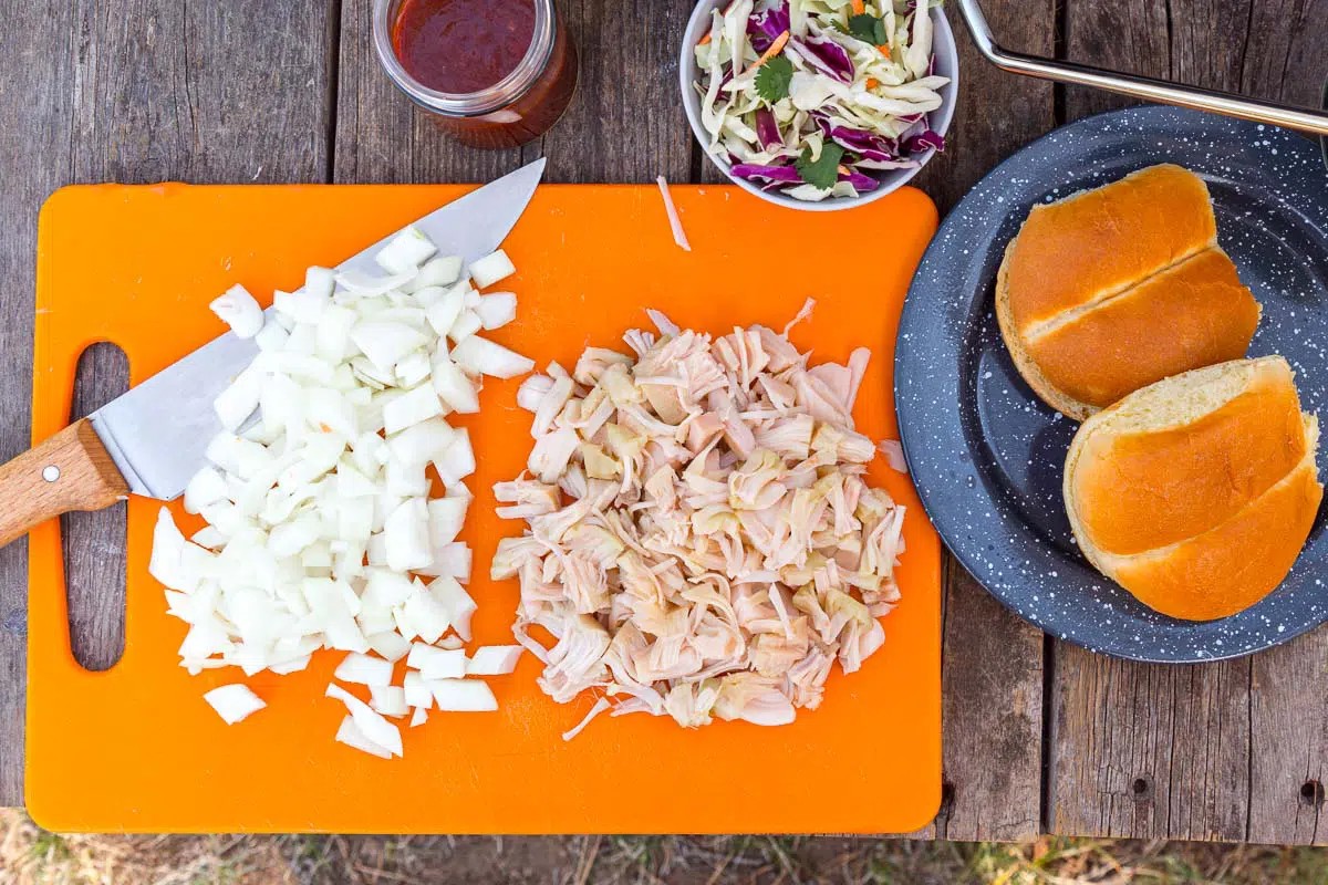 Chopped onions and jackfruit on an orange cutting board