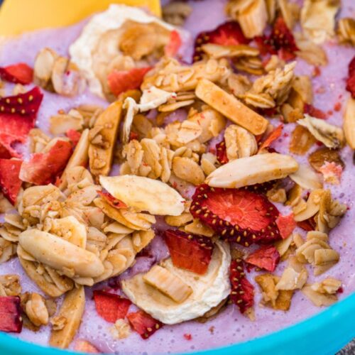 Close up of yogurt, granola, and fruit in a blue bowl