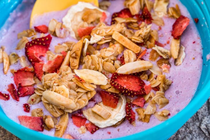 Close up of yogurt, granola, and fruit in a blue bowl