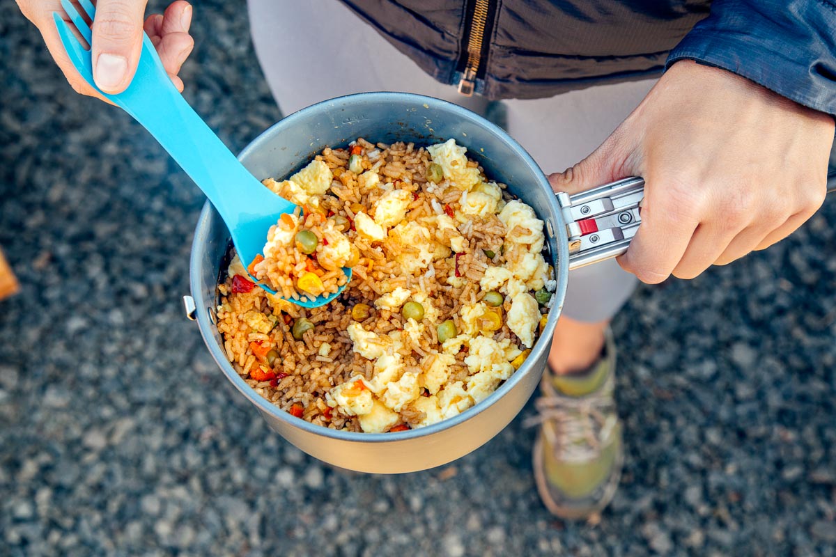 Megan holding fried rice in a backpacking pot