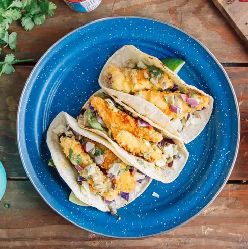 Three fish tacos on a blue plate