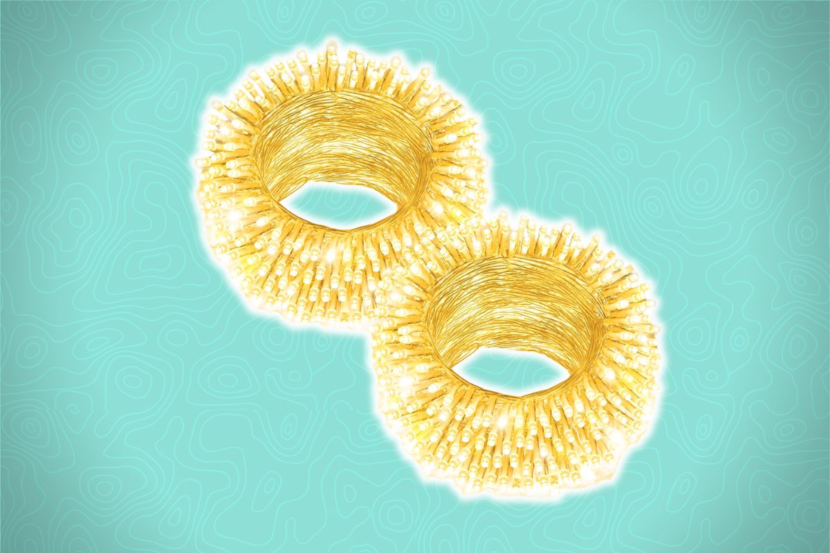 Two gold bangles with textured, spiky surfaces rest on a light blue background with subtle swirling patterns.