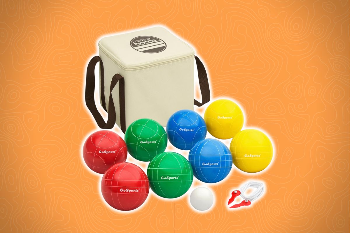 A bocce ball set with red, green, blue, and yellow balls, a white pallino, measuring tool, and beige bag on an orange background.