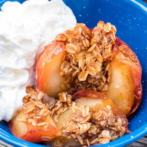 An apple stuffed with oats and whipped cream in a blue bowl.