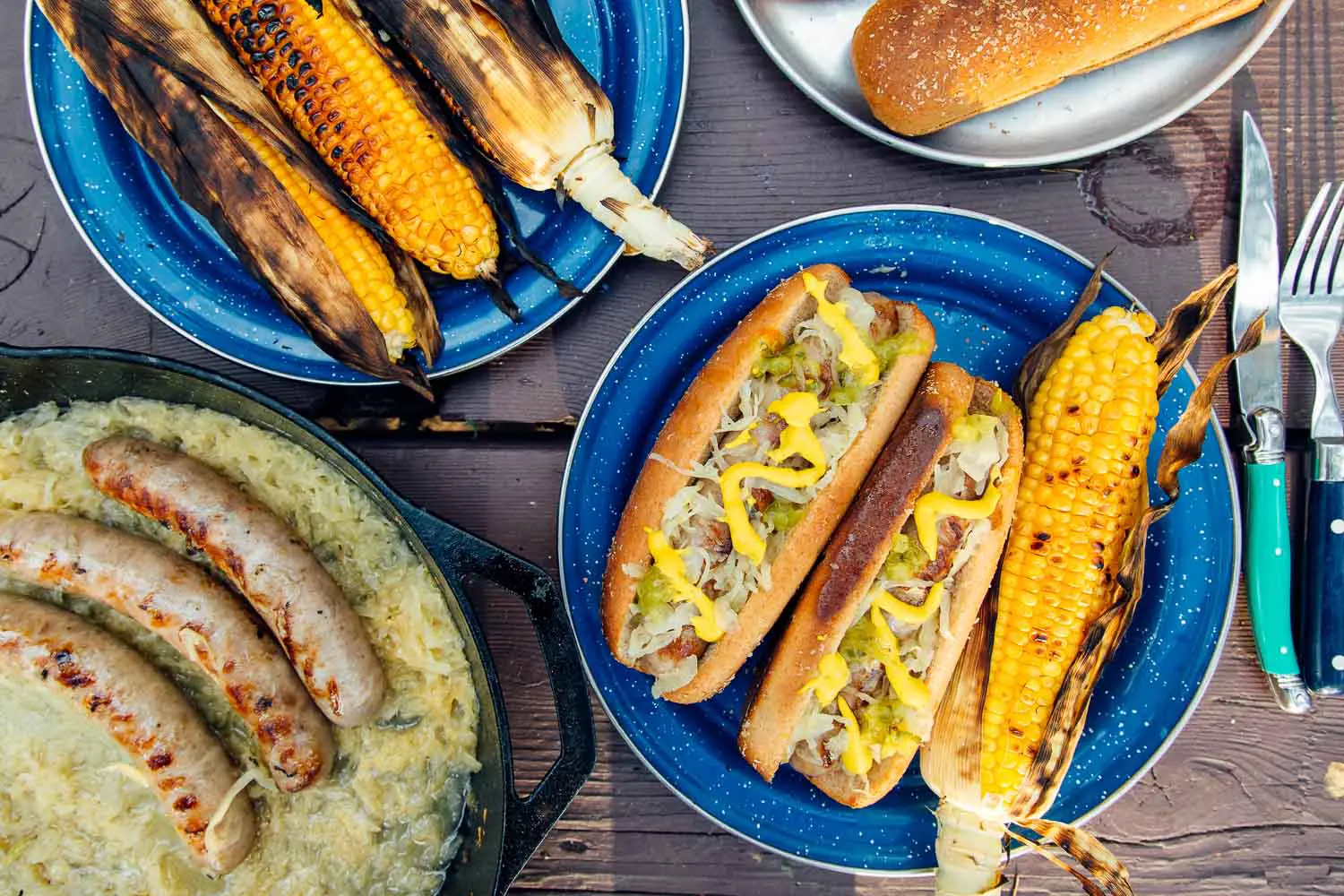 Overhead view of a plate with grilled beer brats, sauerkraut, and grilled corn
