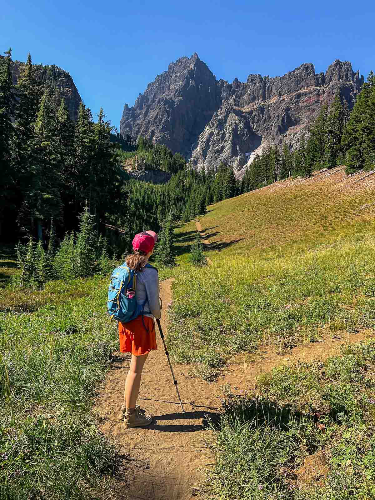 Megan standing on the Canyon Creek Meadows trail looking at Three Fingered Jack