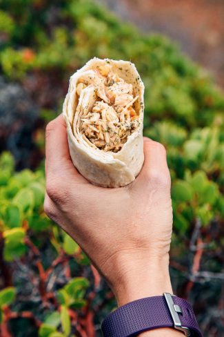 Woman holding a cashew chicken salad wrap
