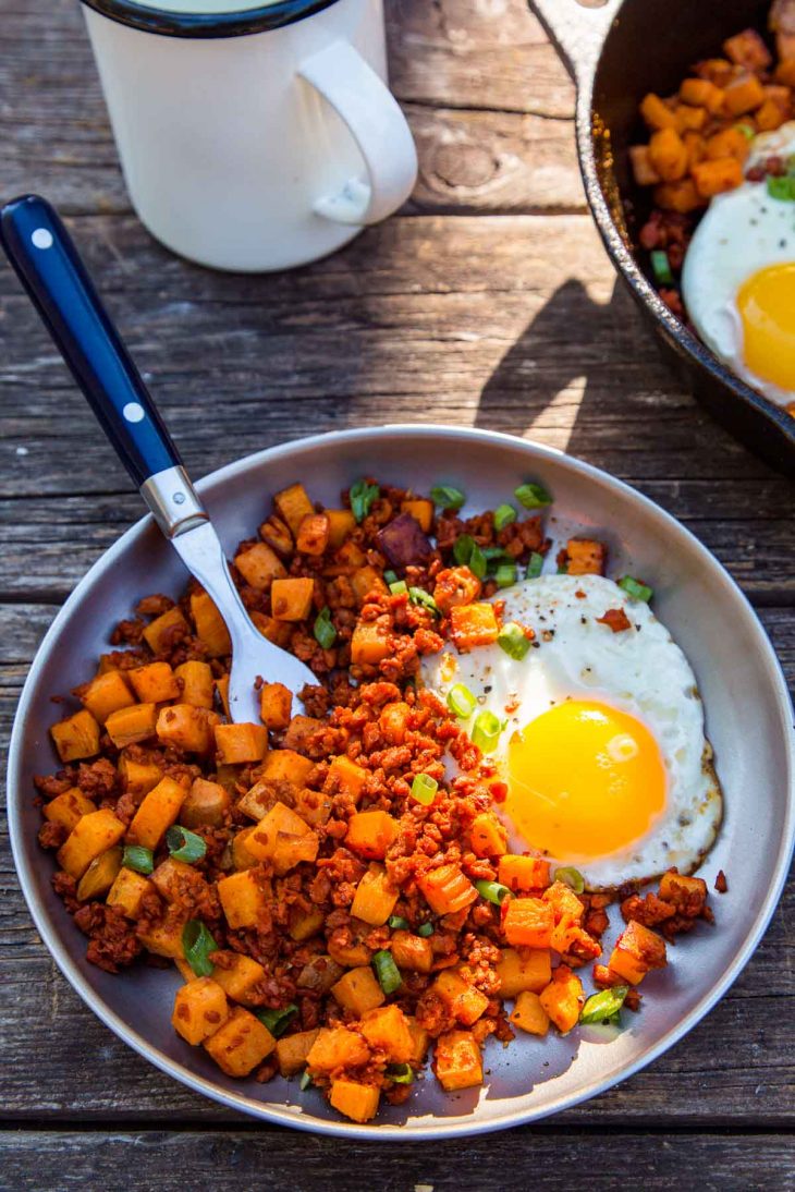 Sweet potato and chorizo hash with an egg on a plate.