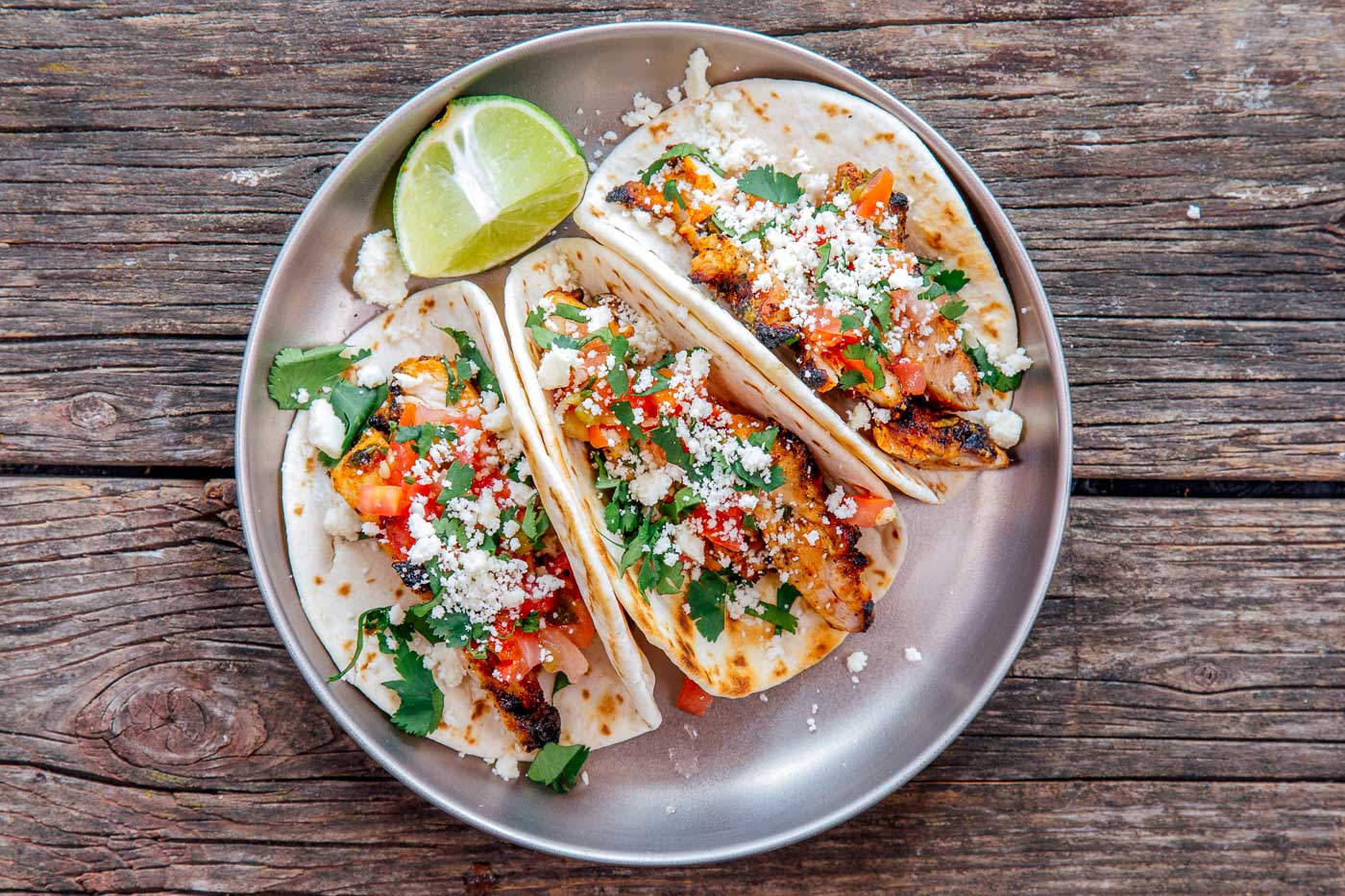Three grilled chicken tacos on a plate