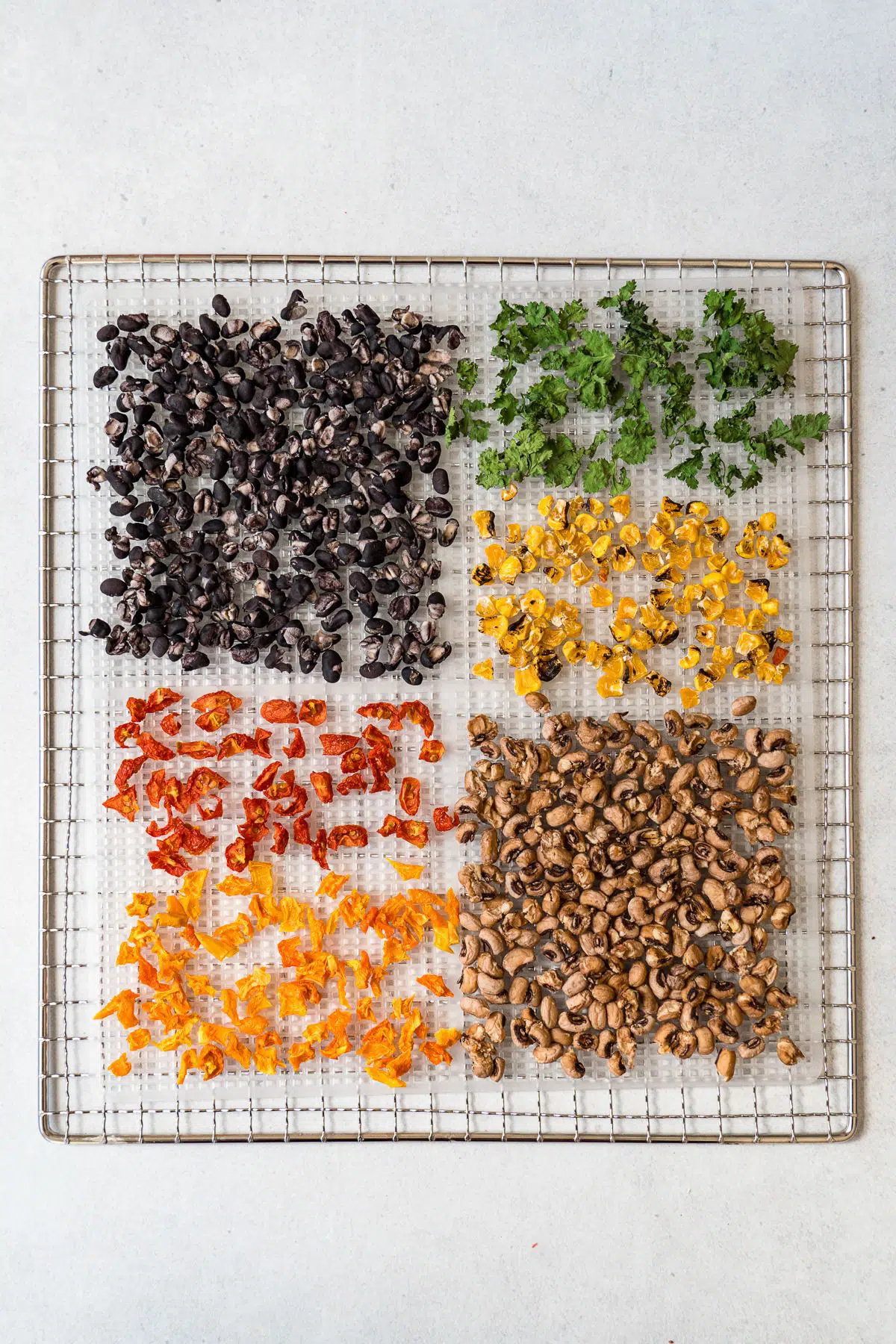 Dehydrated ingredients for cowboy caviar on a dehydrator tray