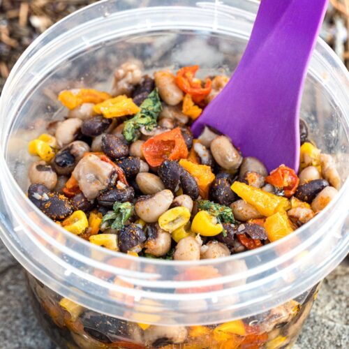 Cowboy caviar in a small bowl with a purple spoon
