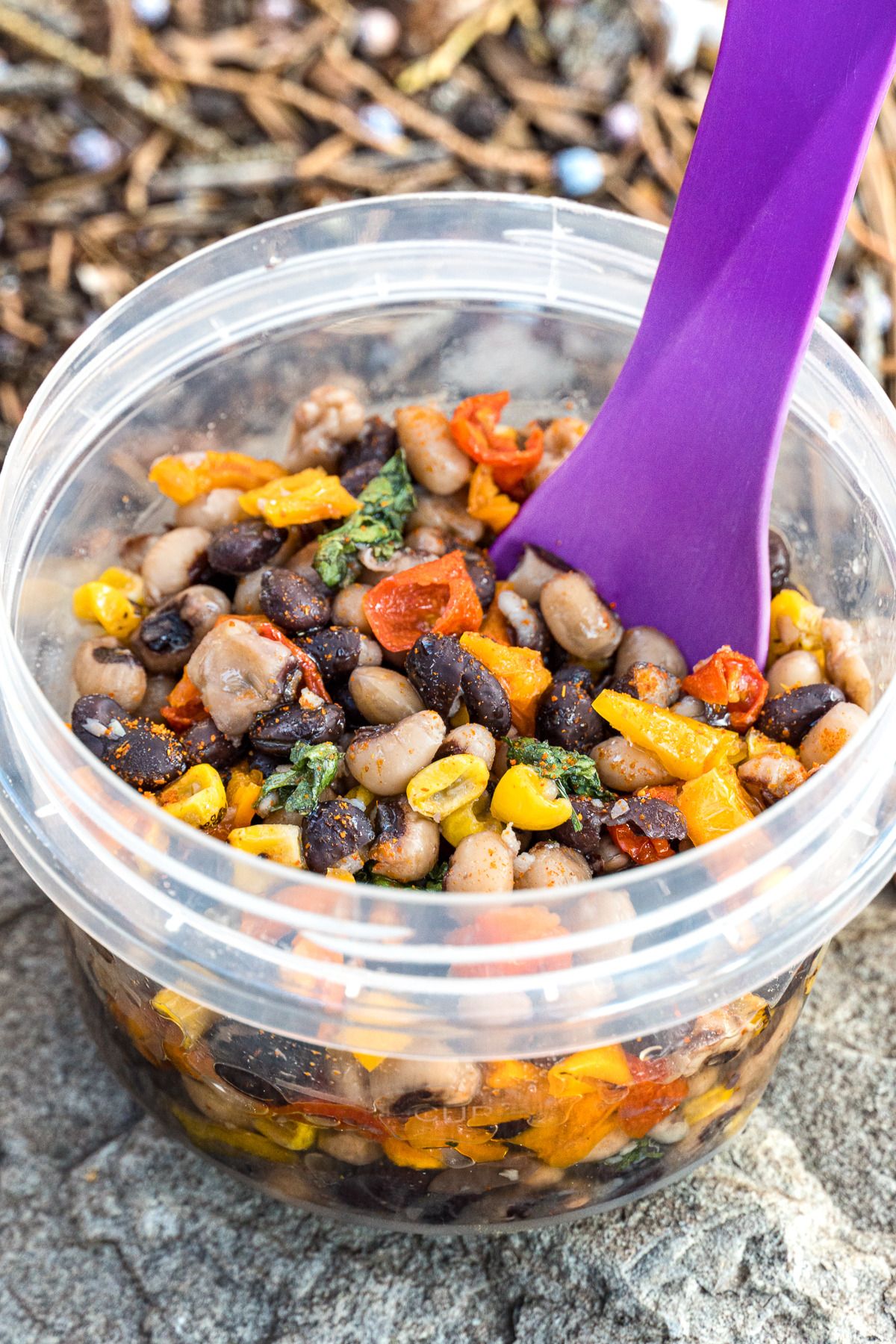 Cowboy caviar in a small bowl with a purple spoon