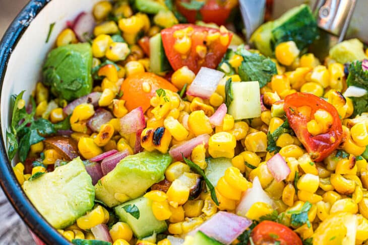 Corn salad with avocado, tomatoes, and cucumber
