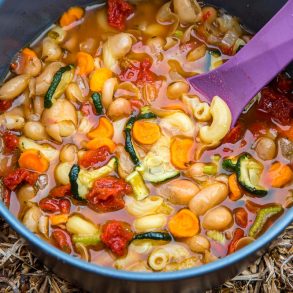 Minestrone in a grey backpacking pot with a purple spoon