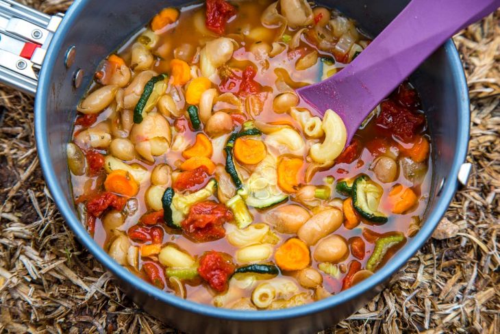 Minestrone in a grey backpacking pot with a purple spoon
