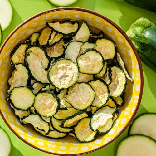 Sunlight streaming over a bowl of dehydrated zucchini chips