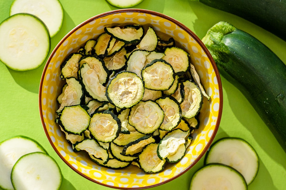Sunlight streaming over a bowl of dehydrated zucchini chips
